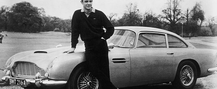 Sean Connery as James Bond, leaning on the Aston Martin DB5 from "Goldfinger"
