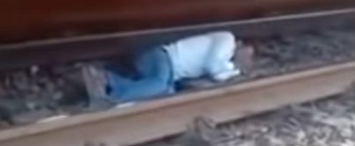Commuter cheats death, lies on the tracks as train passes above him