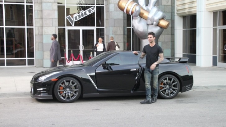 Adam Levine next to a Nissan GT-R
