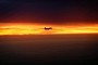 Mighty Heavy Bomber Looks Puny in Orange Sky Over Red Sea