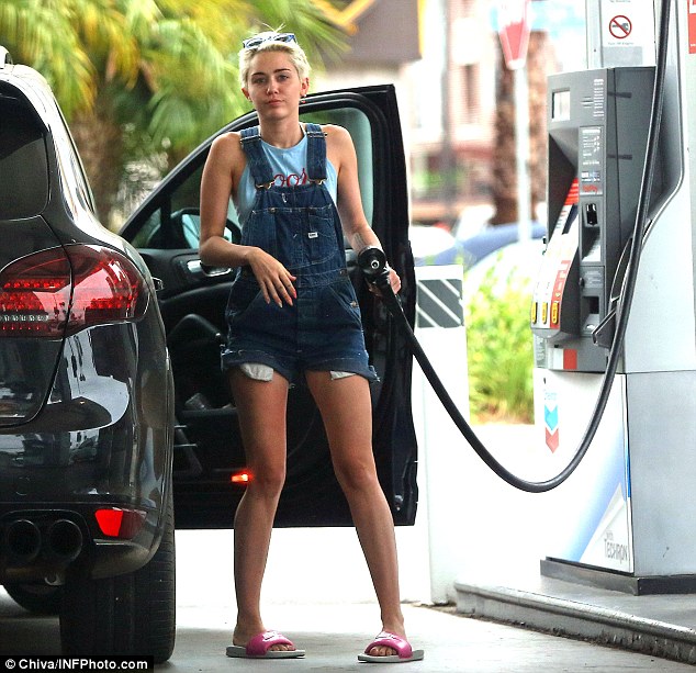 Miley Cyrus filling her Porsche Cayenne GTS with gas