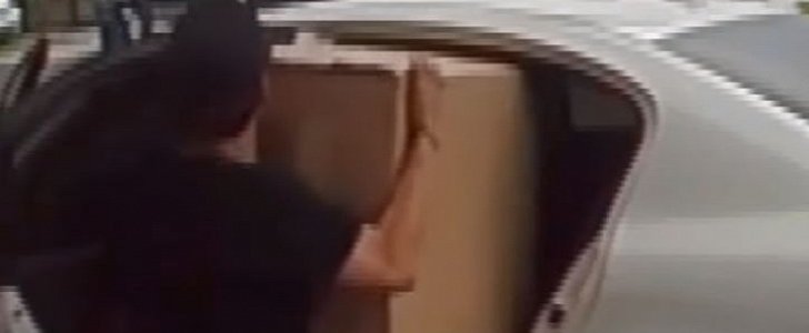 "Porch pirate" desperately tries to fit oversize package in his backseat