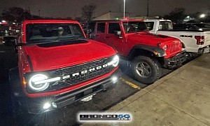 Red 2021 Ford Bronco Wildtrak Poses Next to Red Lifted Jeep Wrangler JKU
