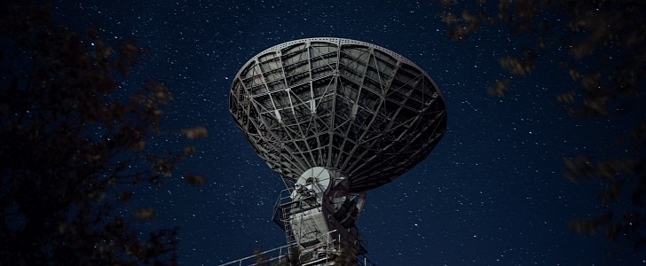 Radio telescope against sky with stars
