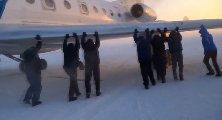 Russians Push an Airplane in Siberia after its Wheels Froze to the Ground