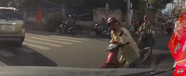 Scooter rider refuses to let go of his phone even as he loses control of the scooter