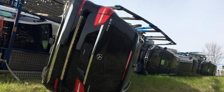 Semi truck carrying Mercedes-Benz SUVs rolls over
