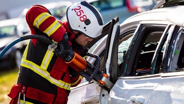 Rescue service specialist receives training using jaws-of-life device on a Volvo that was dropped to simulate a crash