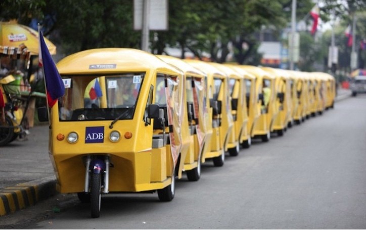 E-trikes are parked next to a sidewalk in Manila
