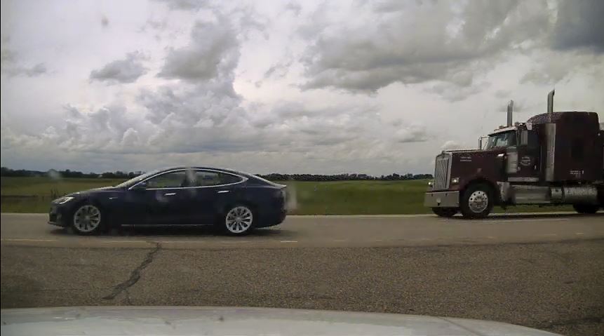 tesla model s speeds down the highway with driver fast asleep in reclined seat