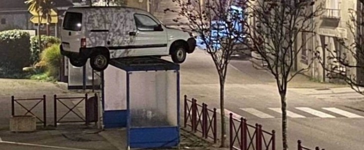 A white van showed up perched on top of a bus shelter, and no one knew how it got there