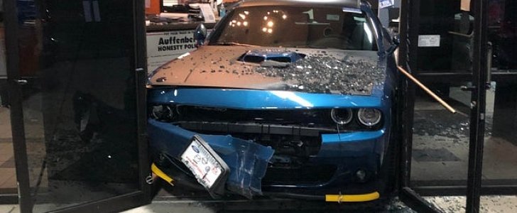 Dodge Challenger abandoned by car thief after it gets stuck in the door frame, as he tries smashing his way through