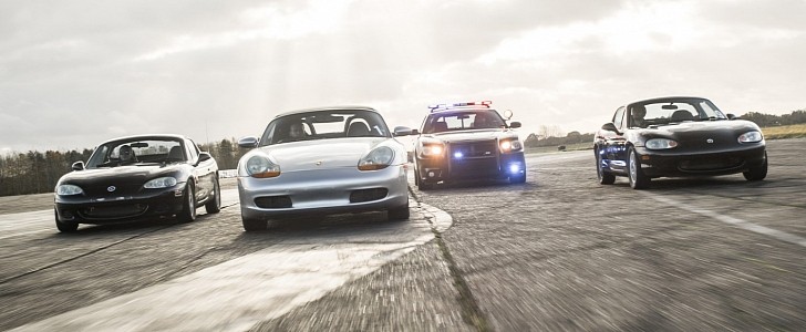 Mazda MX-5 and Porsche Boxster driving with Dodge Charger Police car replica behind them