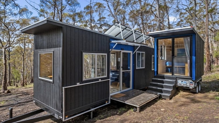 A main tiny house and a minuscule self-contained bedroom on wheels form an unusual compound for off-grid family vacations
