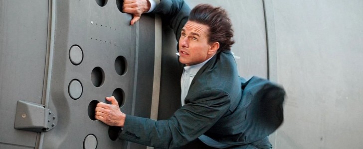 Tom Cruise, as Ethan Hunt, is seen hanging off a military plane 