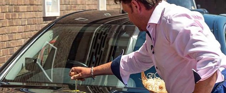 Chef James Martin fries an egg on the hood of a black Mercedes
