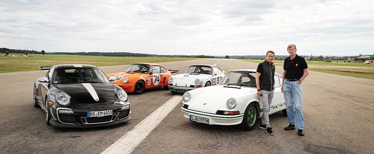Walter Rohrl and Timo Bernhard next to a selection of Porsche 911s