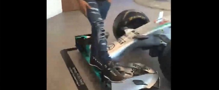 Lewis Hamilton weight-testing the front wing of an F1 car