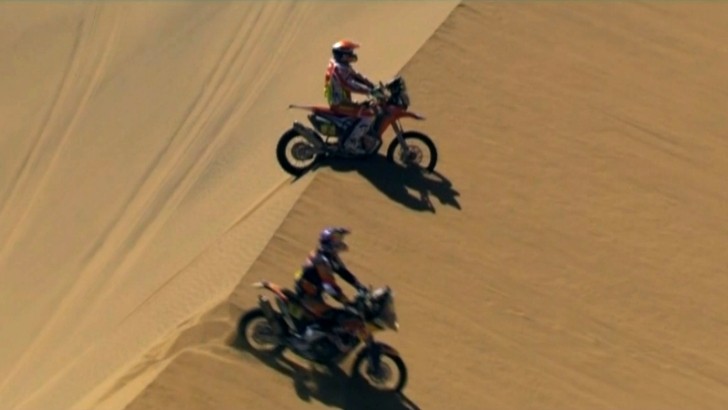 Two riders atop a sand dune, trying to find the best route
