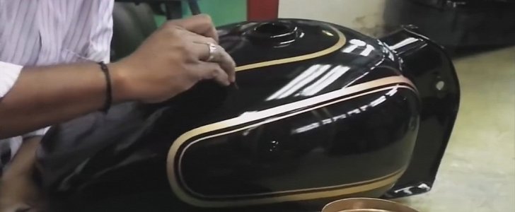 Worker hand paints the pinstripes on the tank of the Royal Enfield Bullet 350