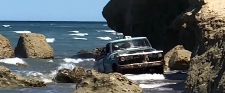 Vintage Ford truck captured exiting the ocean with wood load 